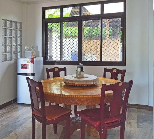 a kitchen with a wooden table and chairs in a kitchen at Sofias House Rental in Tagbilaran City