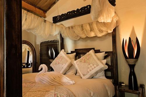 a bedroom with a bed with a swan on it at De Loft Guesthouse in Piet Retief