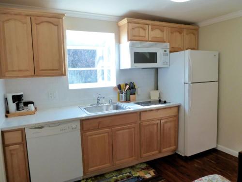 a kitchen with a white refrigerator and a sink at Americas Best Value Inn Royal Carriage in Jamestown
