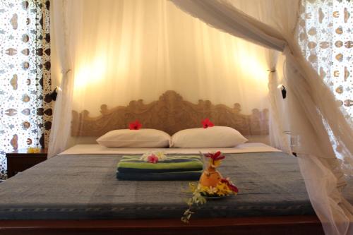 a bed with two pillows and a canopy at Villa Campi Sorga in Senggigi 