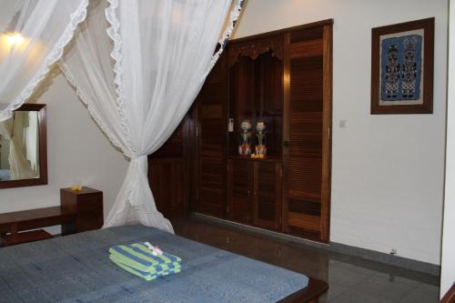 a bedroom with a bed with a white curtain at Villa Campi Sorga in Senggigi 