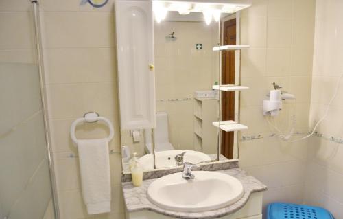 a bathroom with a sink and a mirror at BJB Apartamento in Olhão
