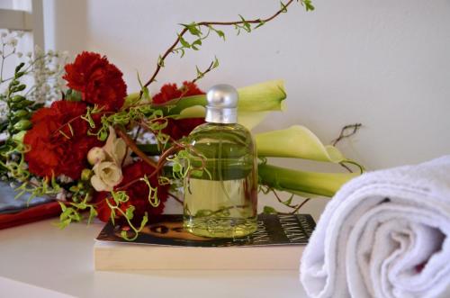 uma garrafa de óleo sentada numa mesa com flores em Appartamento Le Vele em Garda