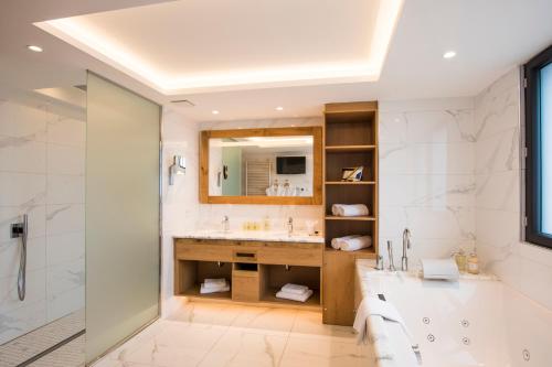 a bathroom with a sink, toilet, and bathtub at Hostellerie Des Châteaux & Spa in Ottrott