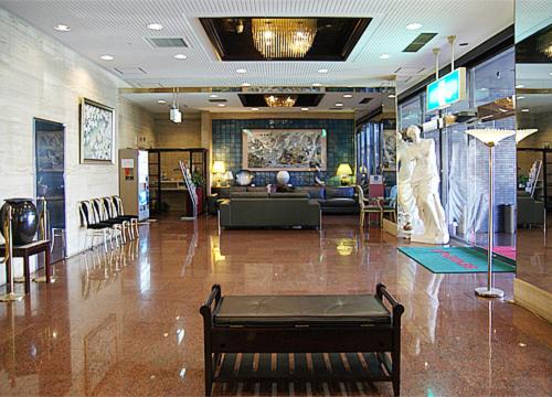 a lobby with a couch and a table in a building at Kurume Station Hotel in Kurume