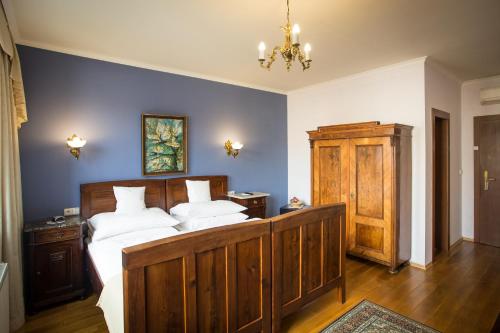 
a bedroom with a bed and a dresser at Hotel Bojnický Vínny Dom in Bojnice
