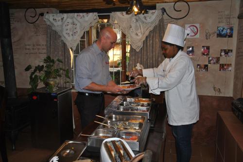 twee mannen die in een keuken eten klaarmaken bij De Loft Guesthouse in Piet Retief