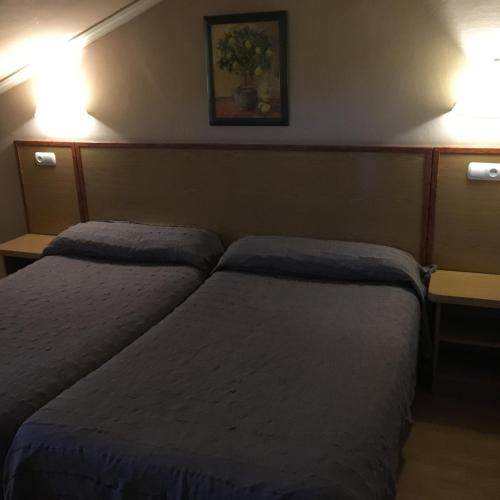 a hotel room with two beds and two lights at Hotel Avenida Leganés in Leganés