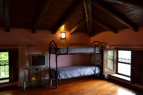 a bedroom with two bunk beds and a tv at Fattoria Alvaneta in Padula