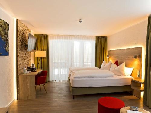 a hotel room with a bed and a window at Elements Hotel Christlessee in Oberstdorf