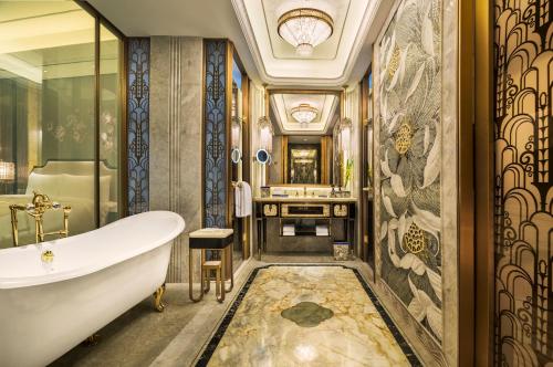 a bathroom with a tub and a sink at Wanda Reign on the Bund in Shanghai