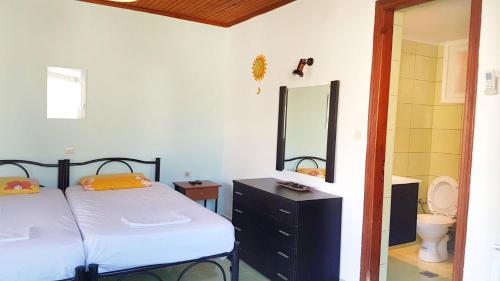 a bedroom with two beds and a sink and a mirror at Villa Panorea in Moraitika