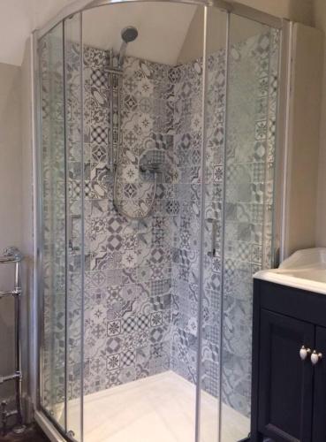 a shower with a glass door in a bathroom at Central Victorian Cottage in Sudbury