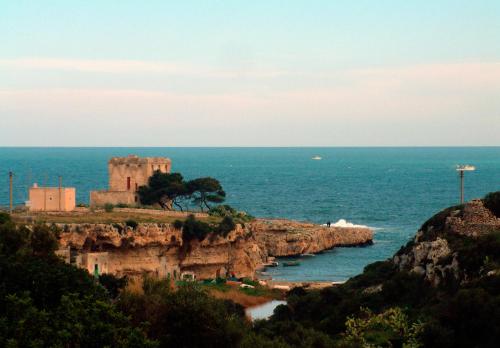 a castle on a cliff near the ocean at A sud Holiday House in Polignano a Mare