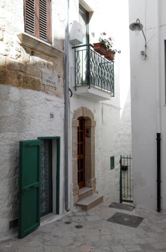 a building with a green door and a balcony at A sud Holiday House in Polignano a Mare