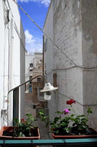 a balcony with twootted plants and a street light at A sud Holiday House in Polignano a Mare