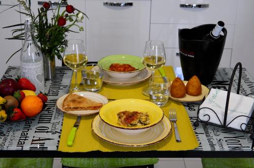a table with plates of food and glasses of wine at A sud Holiday House in Polignano a Mare