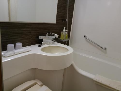 橿原的住宿－橿原市大和酒店，白色的浴室设有水槽和卫生间。