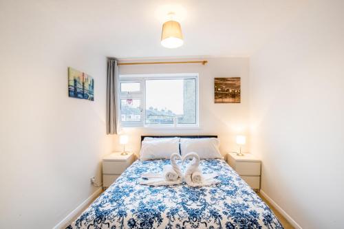a bedroom with a bed with two white shoes on it at Comfy 2BR Flat with Wi-Fi in Bishop's Stortford in Bishops Stortford