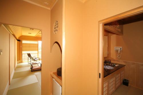 La salle de bains est pourvue d'un lavabo et d'un miroir. dans l'établissement Oiwakeya Ryokan, à Matsumoto