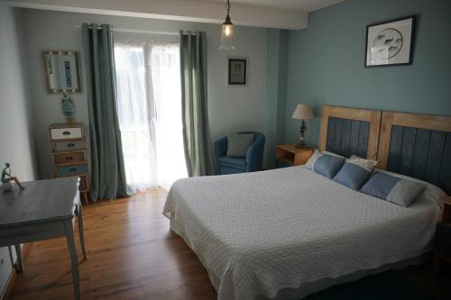PlouhinecにあるMaison d'Hôtes de Kerzineのベッドルーム1室(ベッド1台、デスク、窓付)