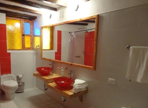 a bathroom with two red sinks and a mirror at Hotel Spa Casa de Adobe Villa de Leyva in Villa de Leyva