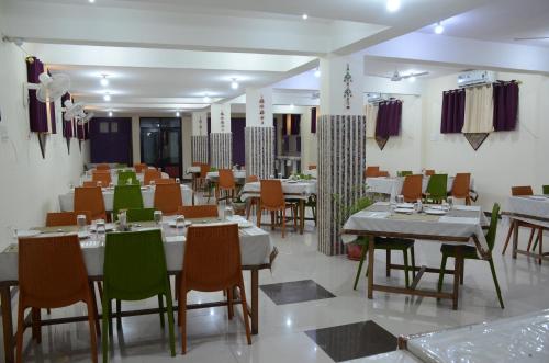 a restaurant with tables and chairs in a room at Hotel Bodh Vilas in Bodh Gaya