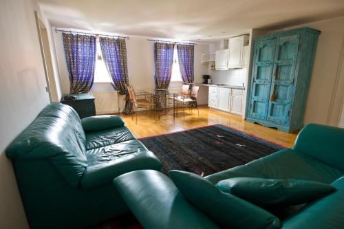 a living room with a leather couch and a kitchen at Bon-Apart in Görlitz