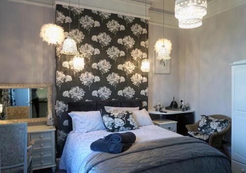 um quarto com uma cama, um espelho e lustres em Chilton House em Oswestry