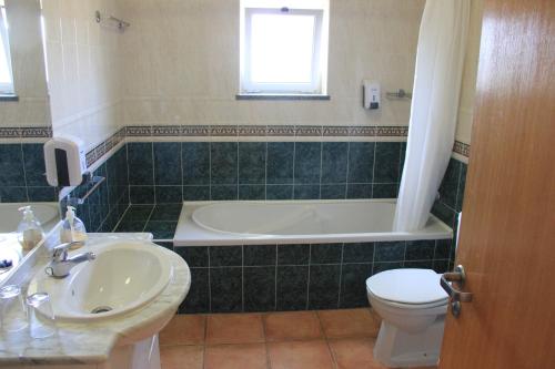 a bathroom with a tub and a sink and a toilet at Apartment Vila Mós in Porto Mós Beach in Lagos