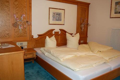 マウテルンドルフにあるAktivhotel Karlaのベッドルーム1室(木製ヘッドボード付きのベッド1台付)