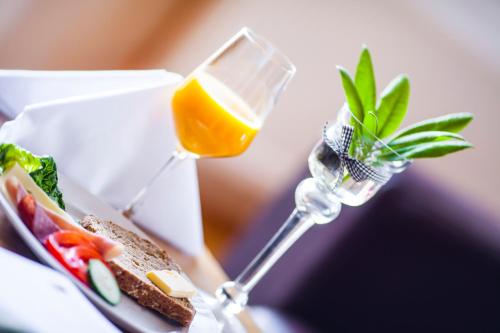 a sandwich and a glass of orange juice on a table at Slottet Apartments in Tysso