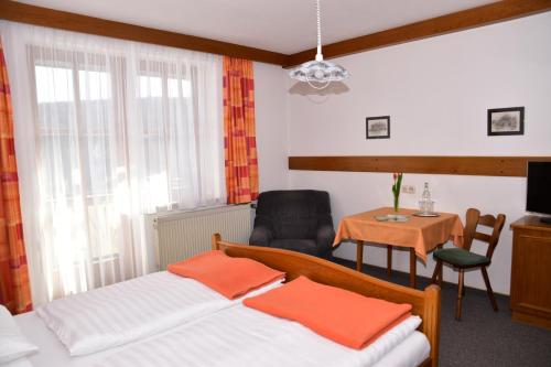 Miesenbachにあるフロリアンホフのベッドルーム1室(ベッド2台、テーブル、椅子付)