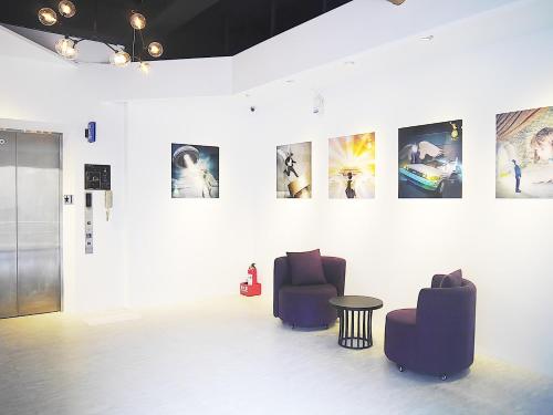 a room with two chairs and a table and pictures on the wall at Time Flyer Hotel in Taichung