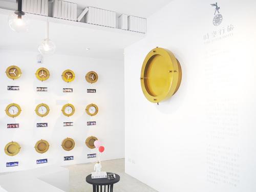 a wall with gold clocks on a white wall at Time Flyer Hotel in Taichung