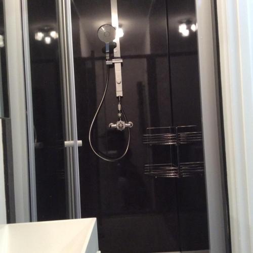 a shower with a hose attached to a window at Olde Lantern Holiday Lets in Ilfracombe