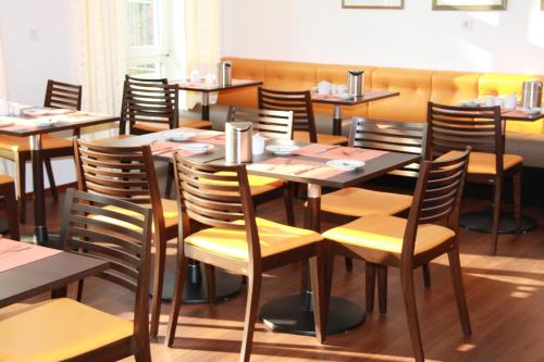 a dining room with wooden tables and chairs at Stadthotel Berggeist in Penzberg