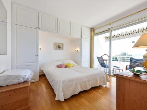 カンヌにあるWelkeys Apartment - Leaderの白いベッドルーム(ベッド1台、バルコニー付)