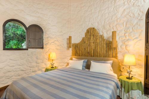 Villa Bournella في إيبسوس: غرفة نوم مع سرير مع مصباحين على الطاولات