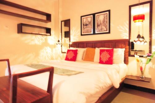 Un dormitorio con una cama grande con almohadas rojas. en Hotel Highnest, en Singapperumālkovil