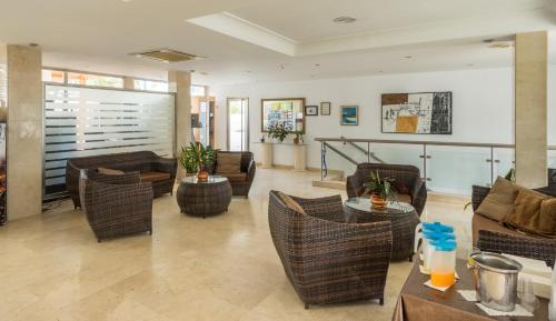 a living room with wicker chairs and tables at BLUESEA Hotel Los Fiscos in Puerto del Carmen