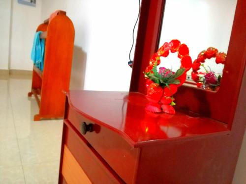 a red dresser with a mirror and flowers on it at Ella Sunrise in Ella
