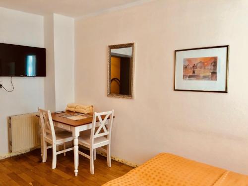 a room with a table and chairs and a mirror at Hotel Mariahilf München in Munich