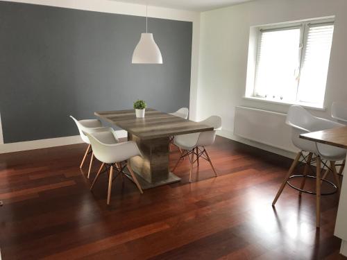 a dining room with a wooden table and white chairs at Amelia in Schodnia Stara