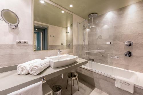 a bathroom with a sink and a mirror and a shower at Catalonia Granada in Granada