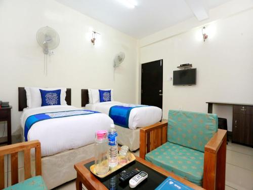 Pokój hotelowy z 2 łóżkami i krzesłem w obiekcie Sophiya Suites w mieście Koczin