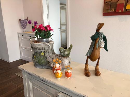 a table with some figurines and a vase with flowers at Scarpapè in Giubiasco