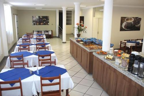 a row of tables in a restaurant with blue napkins at Hotel Muller in Mariana