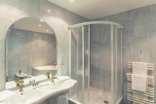 a bathroom with a shower and a sink and a mirror at Hotel Schloss Neustadt-Glewe in Neustadt-Glewe