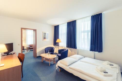 a hotel room with a bed and a desk at Hotel Schloss Neustadt-Glewe in Neustadt-Glewe